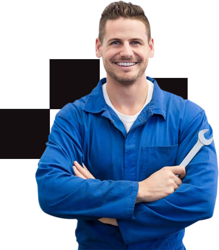 A man in blue work clothes holding a wrench.